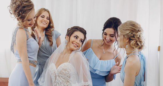 A group of bridesmaids poses together, showcasing their elegant dresses and styled hair by Loxxie Hair.