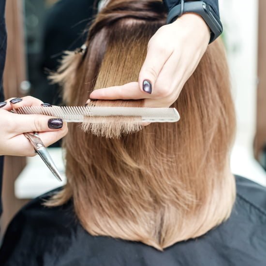 A woman receives a haircut from a hairdresser at Loxxie Hair, showcasing a professional salon environment.