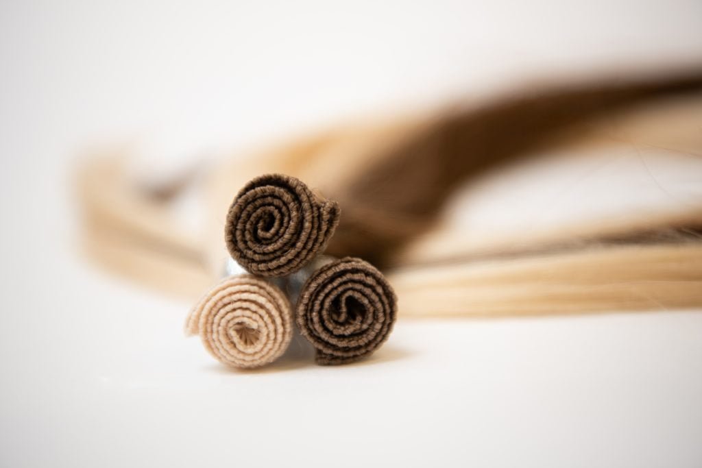 A pair of Loxxie hair extensions featuring a blend of brown and blonde colors.