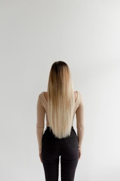 A stylish woman in black leggings and high heels, with Loxxie hair, exuding elegance.