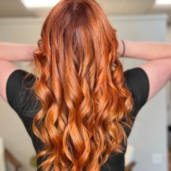 A close-up of a woman with long hair, styled beautifully with Loxxie hair.