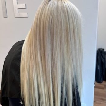 A woman with long, beautiful blonde hair, styled using Loxxie hair, is featured in this vibrant image.