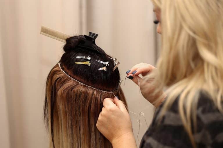 Women are in Loxxie Hair salon, each receiving hair treatments while chatting and enjoying their time together.