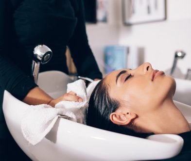 A woman receives a soothing hair wash at Loxxie Hair salon, with gentle water streams enveloping her hair.