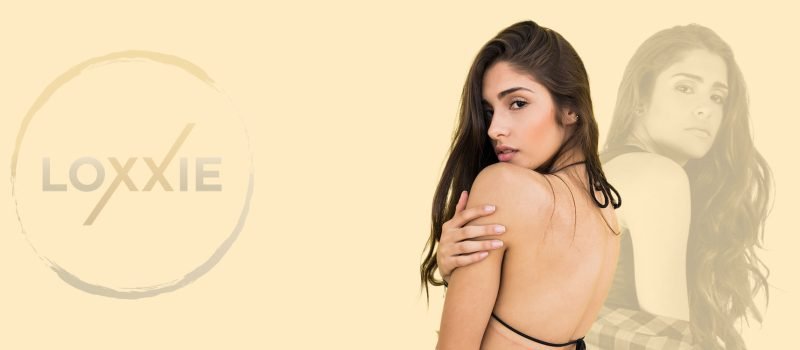 A woman in a bikini top and a man in a suit are featured together, promoting Loxxie Hair's fashionable appeal.