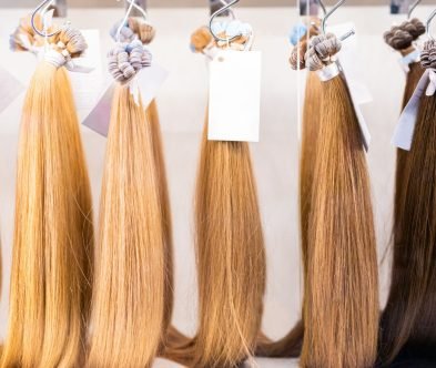 A row of colorful hair extensions displayed in a Loxxie Hair salon, showcasing various styles and lengths.